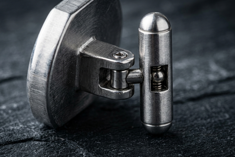 Macro close-up of a cufflink bullet-back mechanism showing the pivot action